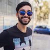 pexels photo 1212984 1212984 Portrait of a smiling man wearing sunglasses outdoors, showcasing modern fashion and style.